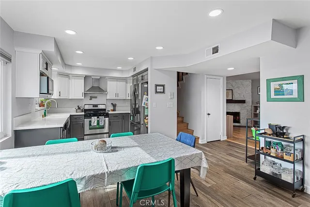 a kitchen with stainless steel appliances granite countertop a stove a refrigerator a kitchen island a table and chairs