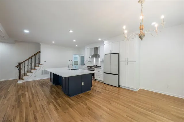 a living room with kitchen island wooden floor and ceiling fan