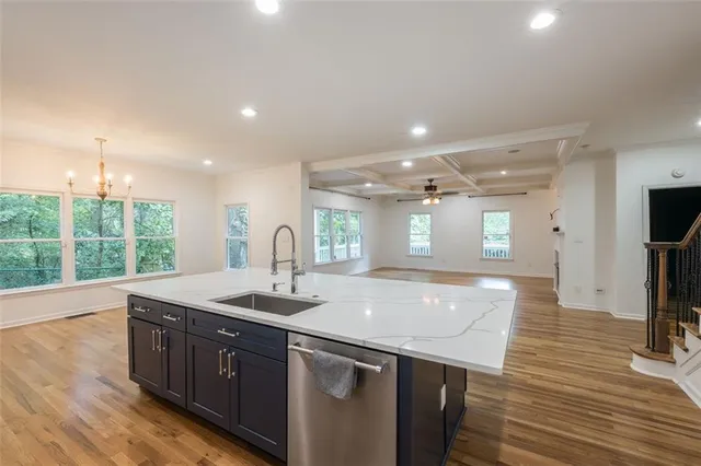 a kitchen with a sink and wooden floor