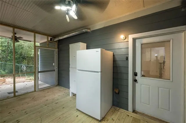 a view of a refrigerator in kitchen and an empty room