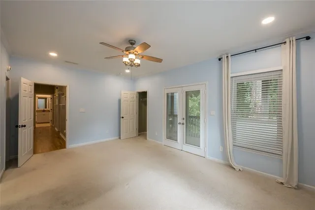 a view of a livingroom with a chandelier fan and windows