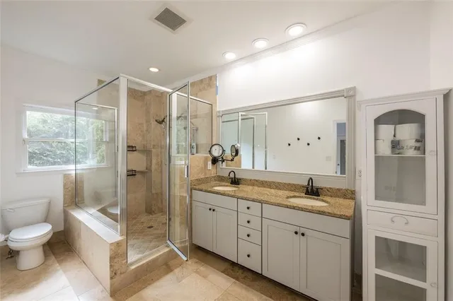 a spacious bathroom with a granite countertop sink mirror and toilet