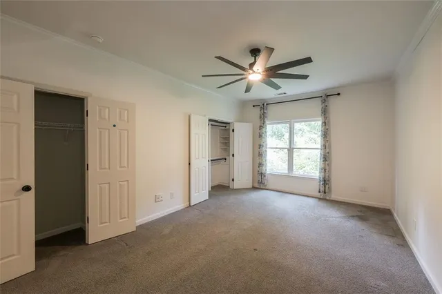 a view of empty room with a ceiling fan and window