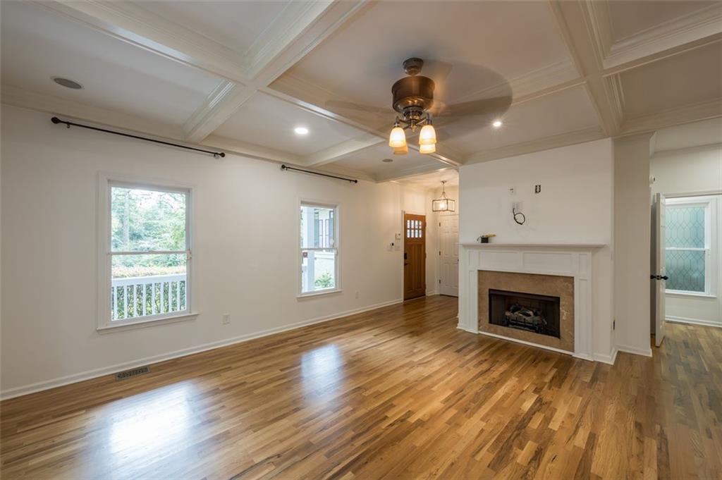 1018 Berne Street Southeast Atlanta, GA 30316 - Photo 7 of 34 a view of an empty room with wooden floor fireplace and a window