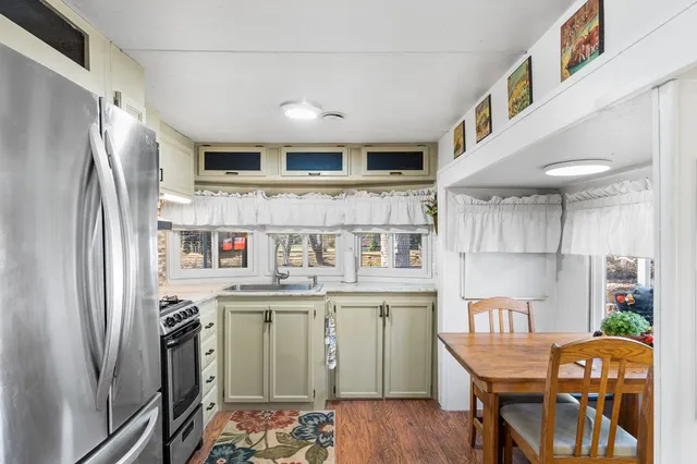 a kitchen with stainless steel appliances granite countertop a refrigerator a stove and a wooden floors