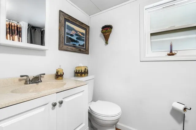 a bathroom with a toilet sink and mirror