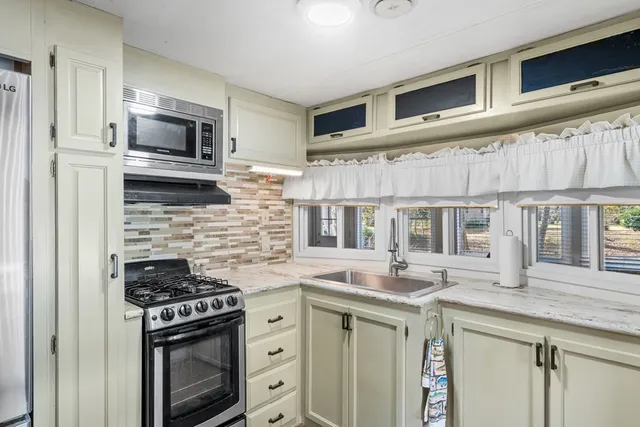 a kitchen with stainless steel appliances granite countertop a stove microwave and cabinets