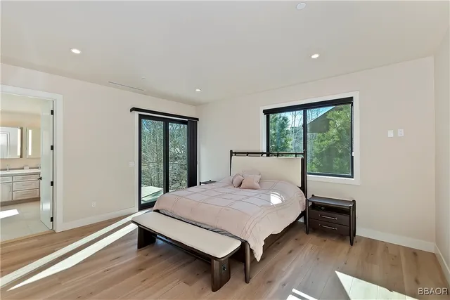 a large bedroom with a bed and wooden floor