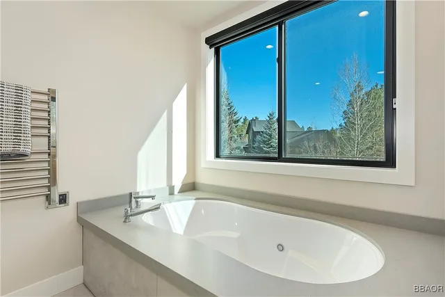 a bathroom with a granite countertop sink and a large mirror