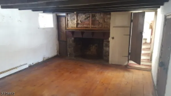 a view of an empty room with a fireplace and a window