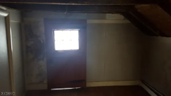 a view of a small space with wooden floor and a window