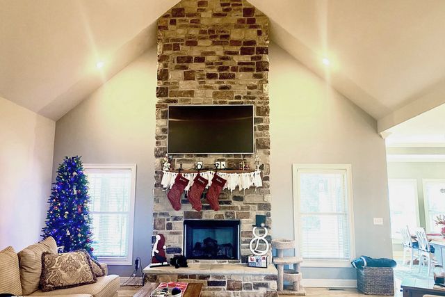 a living room with furniture a flat screen tv and a fireplace