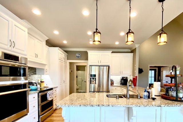 a kitchen with stainless steel appliances kitchen island granite countertop a sink and cabinets
