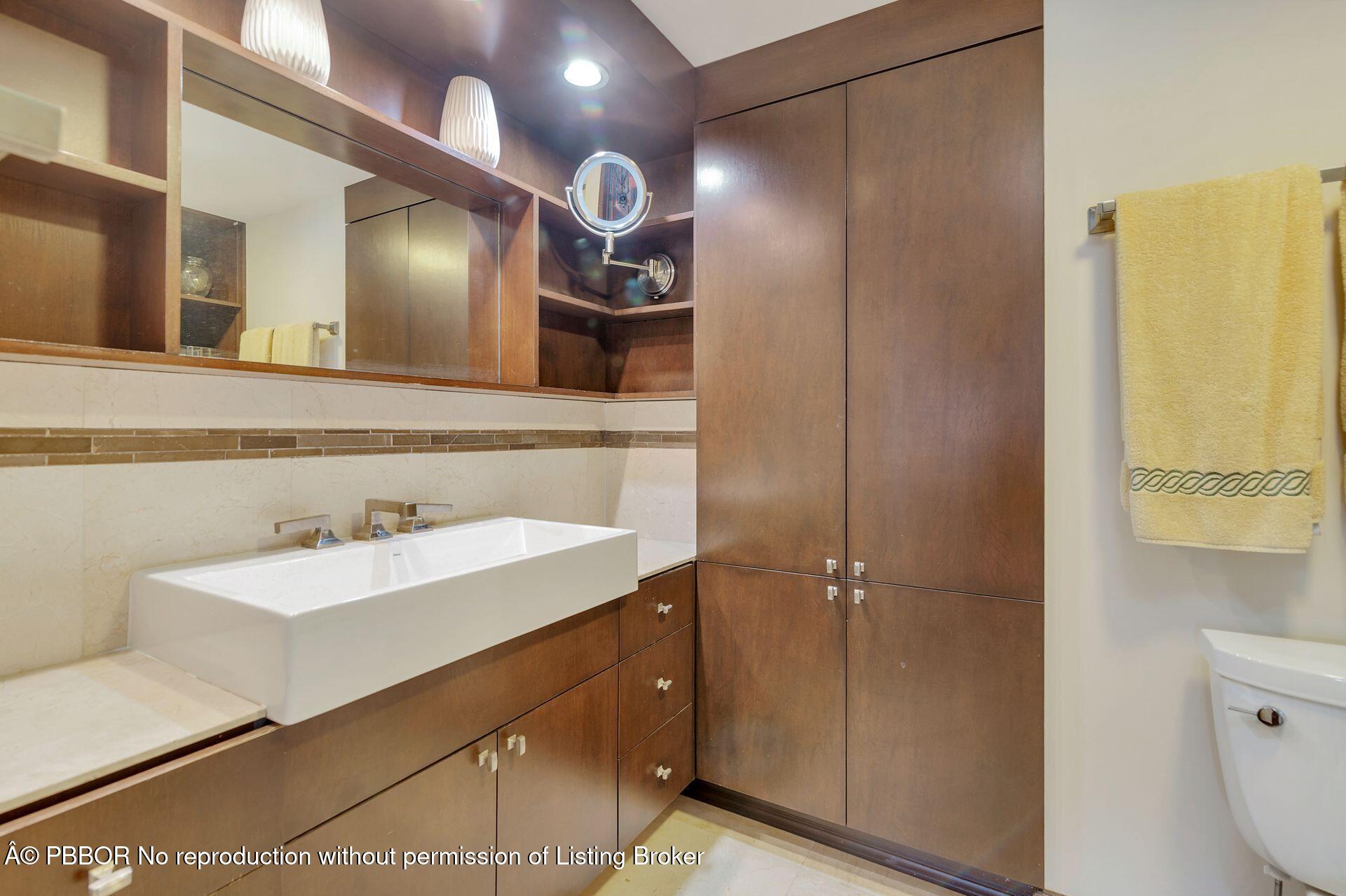 170 North Ocean Boulevard, Unit 409 Palm Beach, FL 33480 - Photo 11 of 34 a bathroom with a sink a toilet and mirror