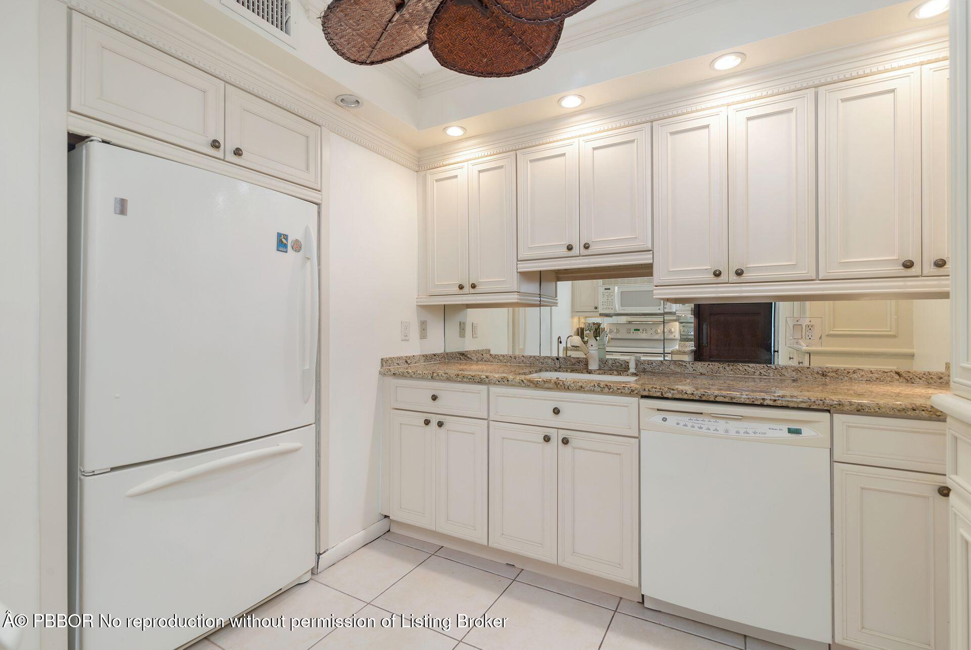 170 North Ocean Boulevard, Unit 409 Palm Beach, FL 33480 - Photo 7 of 34 a kitchen with granite countertop cabinets and white stainless steel appliances