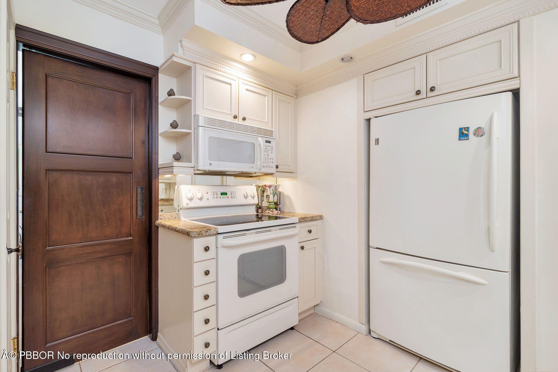 170 North Ocean Boulevard, Unit 409 Palm Beach, FL 33480 - Photo 8 of 34 a kitchen with cabinets and stainless steel appliances