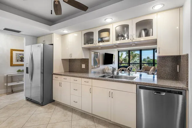 a kitchen with stainless steel appliances granite countertop a refrigerator and a sink