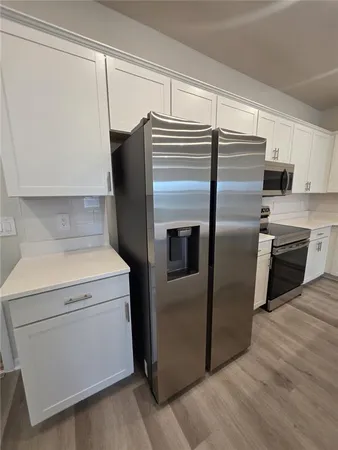 a kitchen with metallic refrigerator and microwave