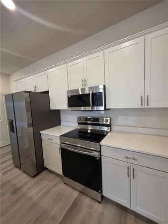 a kitchen with stainless steel appliances white cabinets and a stove