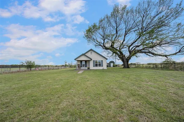 a house with huge green field in front of it