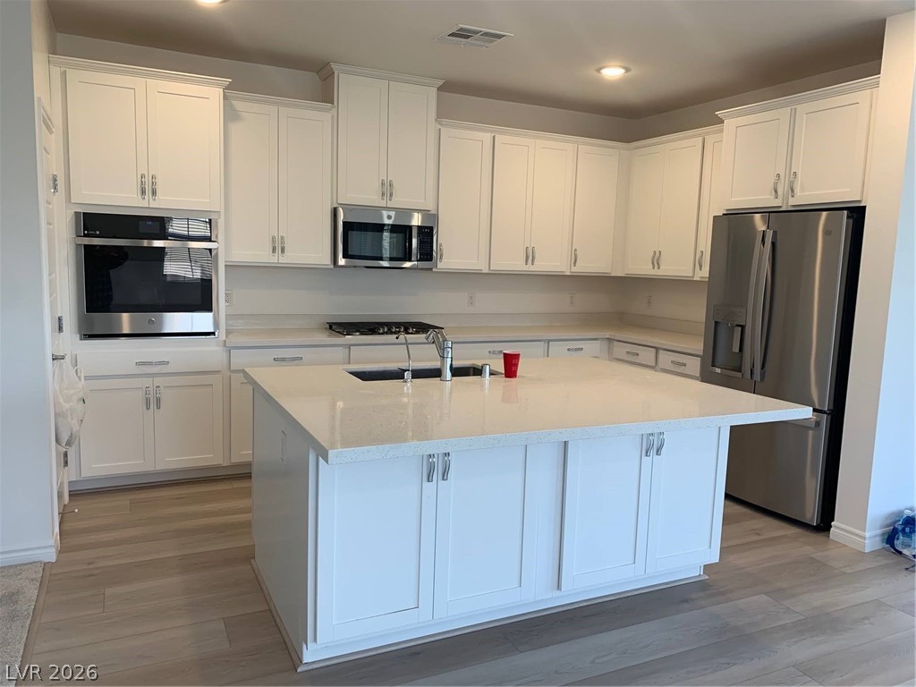 2555 Hampton Road, Unit 7109 Henderson, NV 89052 - Photo 14 of 34 Modern kitchen with white cabinetry features stainless steel appliances and a spacious center island.