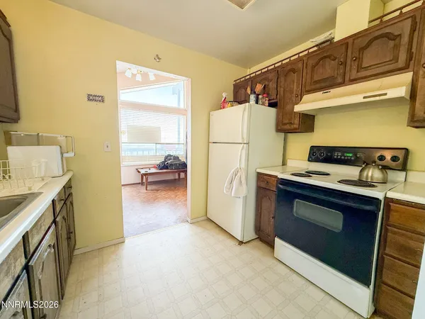 a kitchen with a refrigerator and a stove top oven
