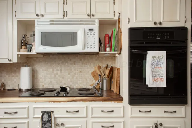 a kitchen with granite countertop white cabinets and black appliances
