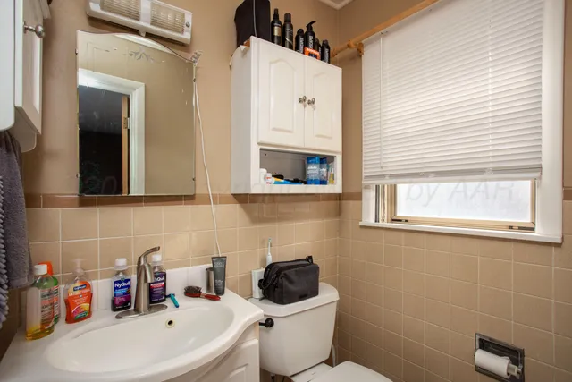 a bathroom with a sink mirror and toilet