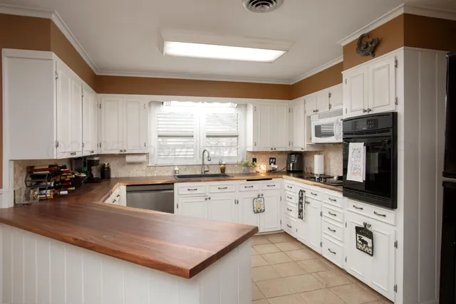 a kitchen with kitchen island granite countertop a sink counter top space and cabinets