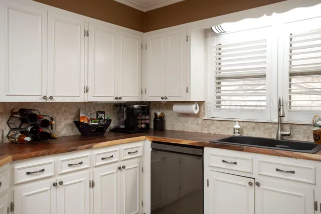 a kitchen with granite countertop white cabinets and sink