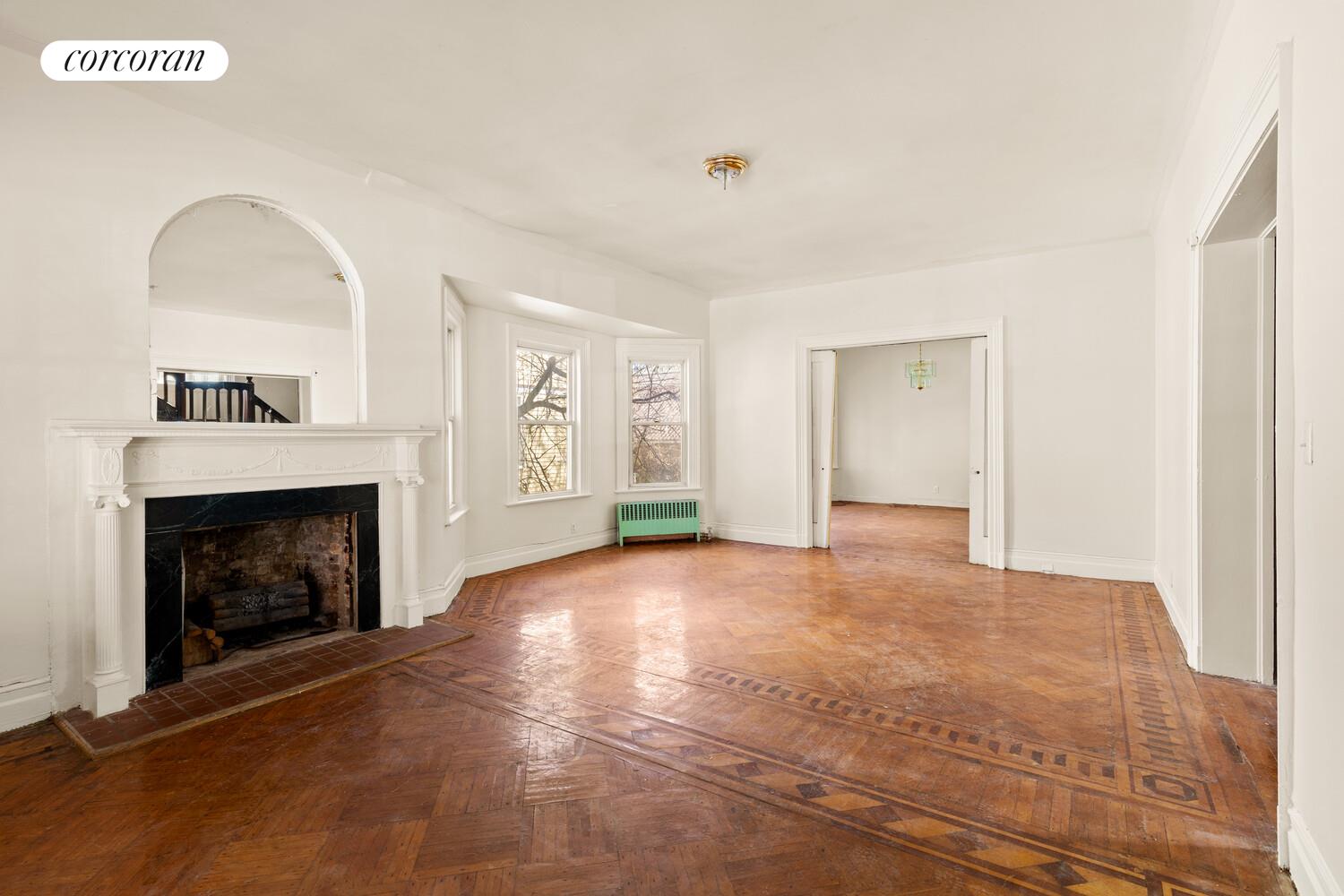 86 Lincoln Road Brooklyn, NY 11225 - Photo 4 of 12 a view of empty room with fireplace and fan
