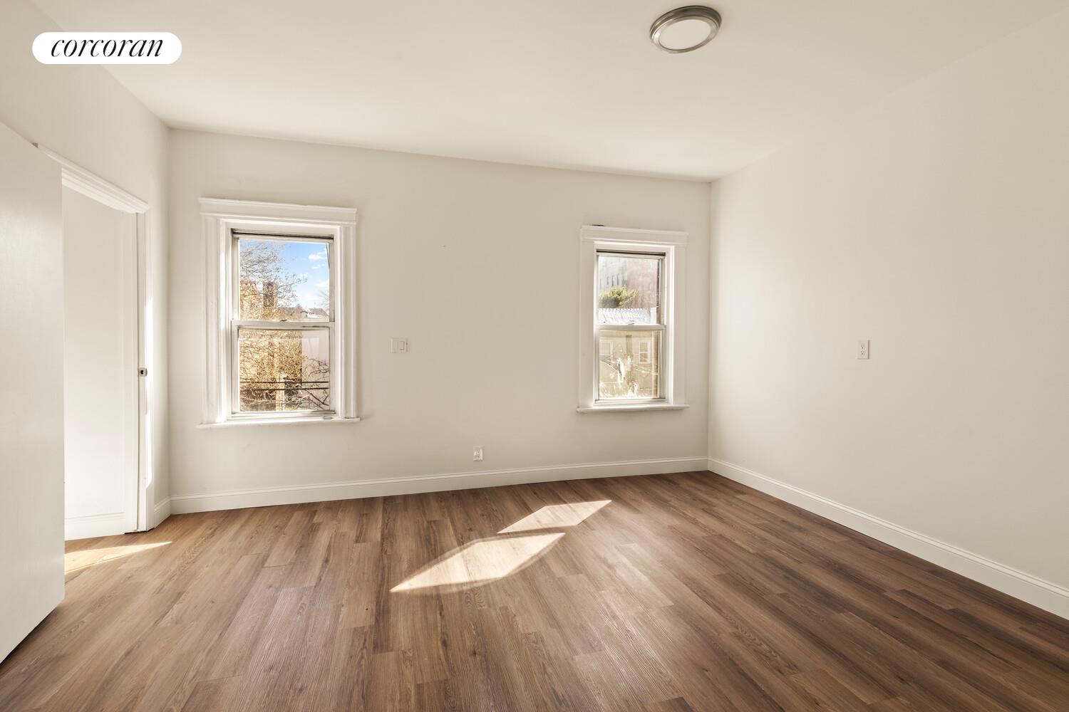 86 Lincoln Road Brooklyn, NY 11225 - Photo 9 of 12 an empty room with wooden floor and windows
