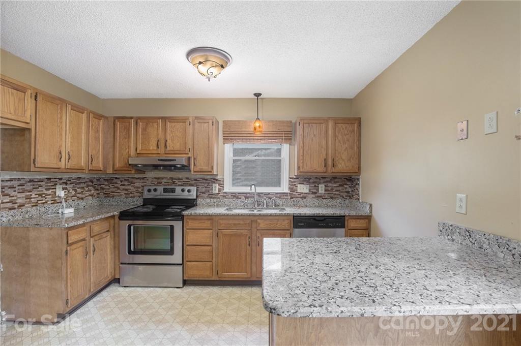 5625 Beaconsfield Road Charlotte, NC 28214 - Photo 4 of 21 a kitchen with stainless steel appliances granite countertop a stove a sink and a microwave