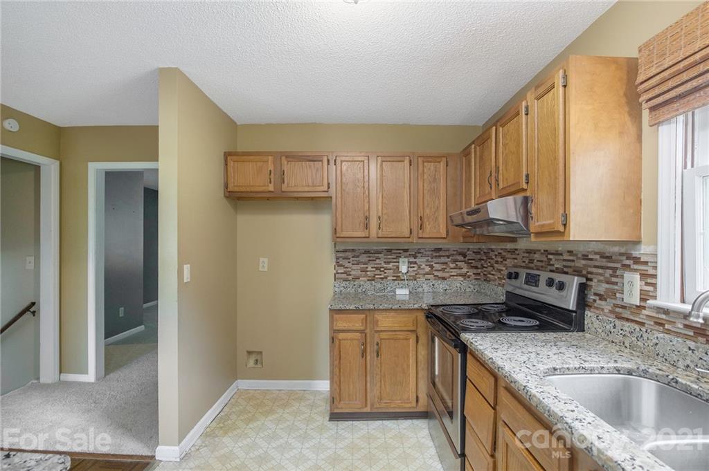 5625 Beaconsfield Road Charlotte, NC 28214 - Photo 6 of 21 a kitchen with stainless steel appliances granite countertop a sink stove and refrigerator