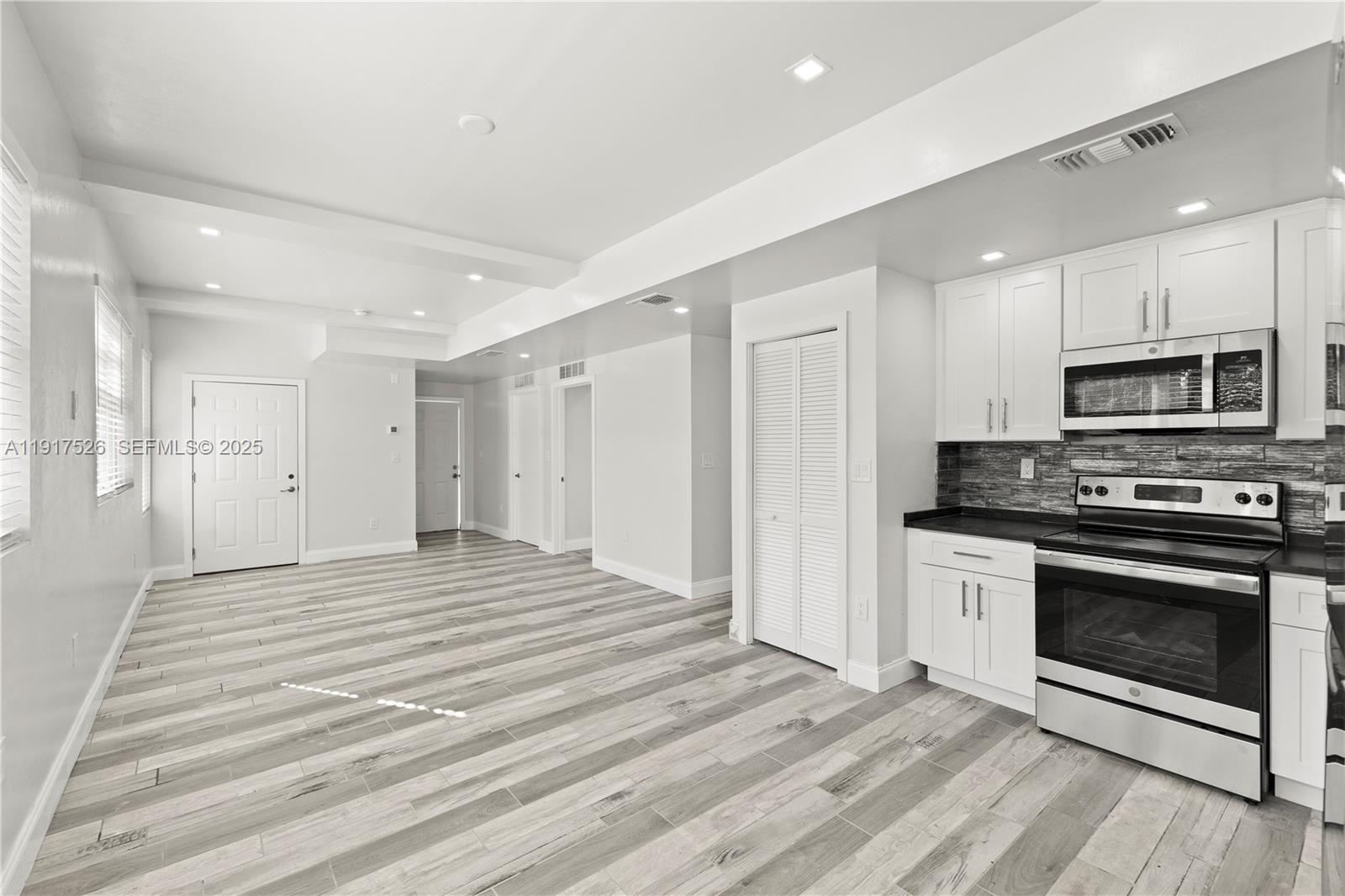 305 Northwest 58th Street Miami, FL 33127 - Photo 13 of 20 a view of a kitchen with a stove microwave and cabinets