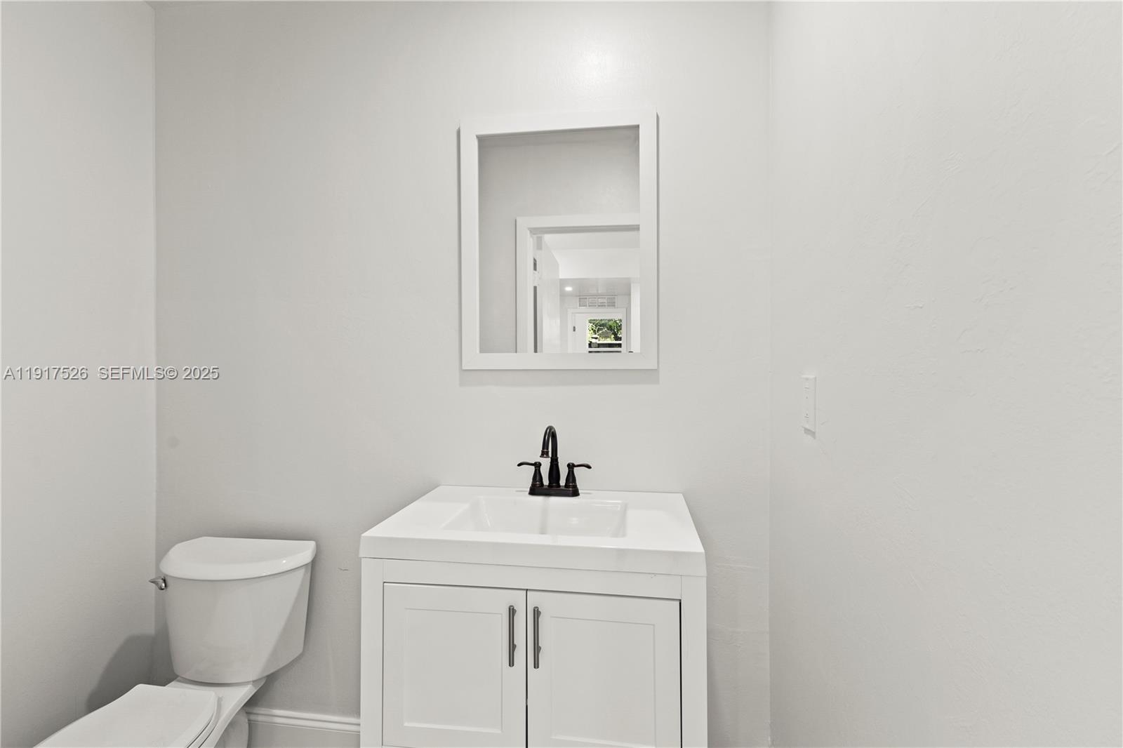 305 Northwest 58th Street Miami, FL 33127 - Photo 20 of 20 a bathroom with a toilet sink and mirror