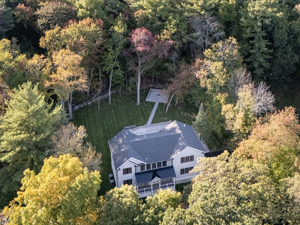 a view of a house with a yard and a large tree