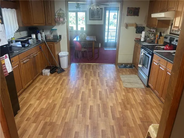 a kitchen with sink a refrigerator and wooden cabinets