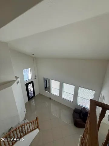 a spacious bedroom with a bed and a lamp on dresser