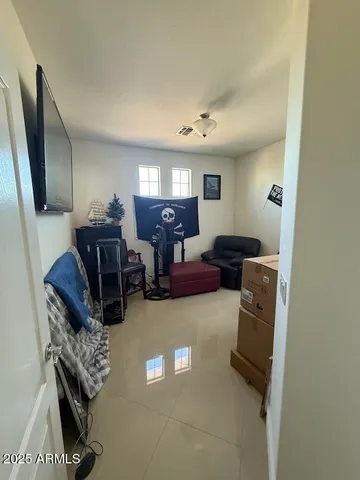 a living room with furniture and a refrigerator