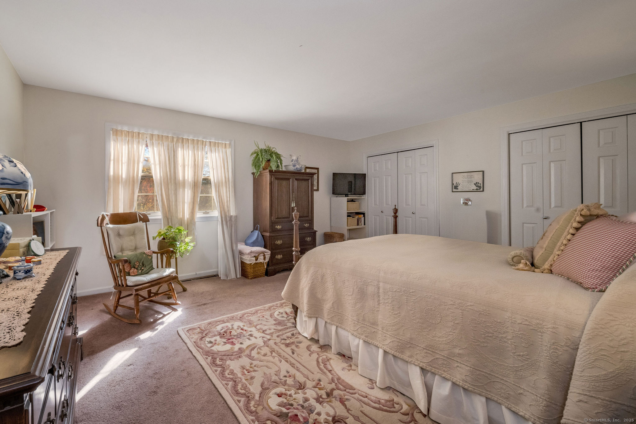 45 Wilshire Road, Unit 45 Madison, CT 06443 - Photo 12 of 25 a bedroom with a bed a large window and chair