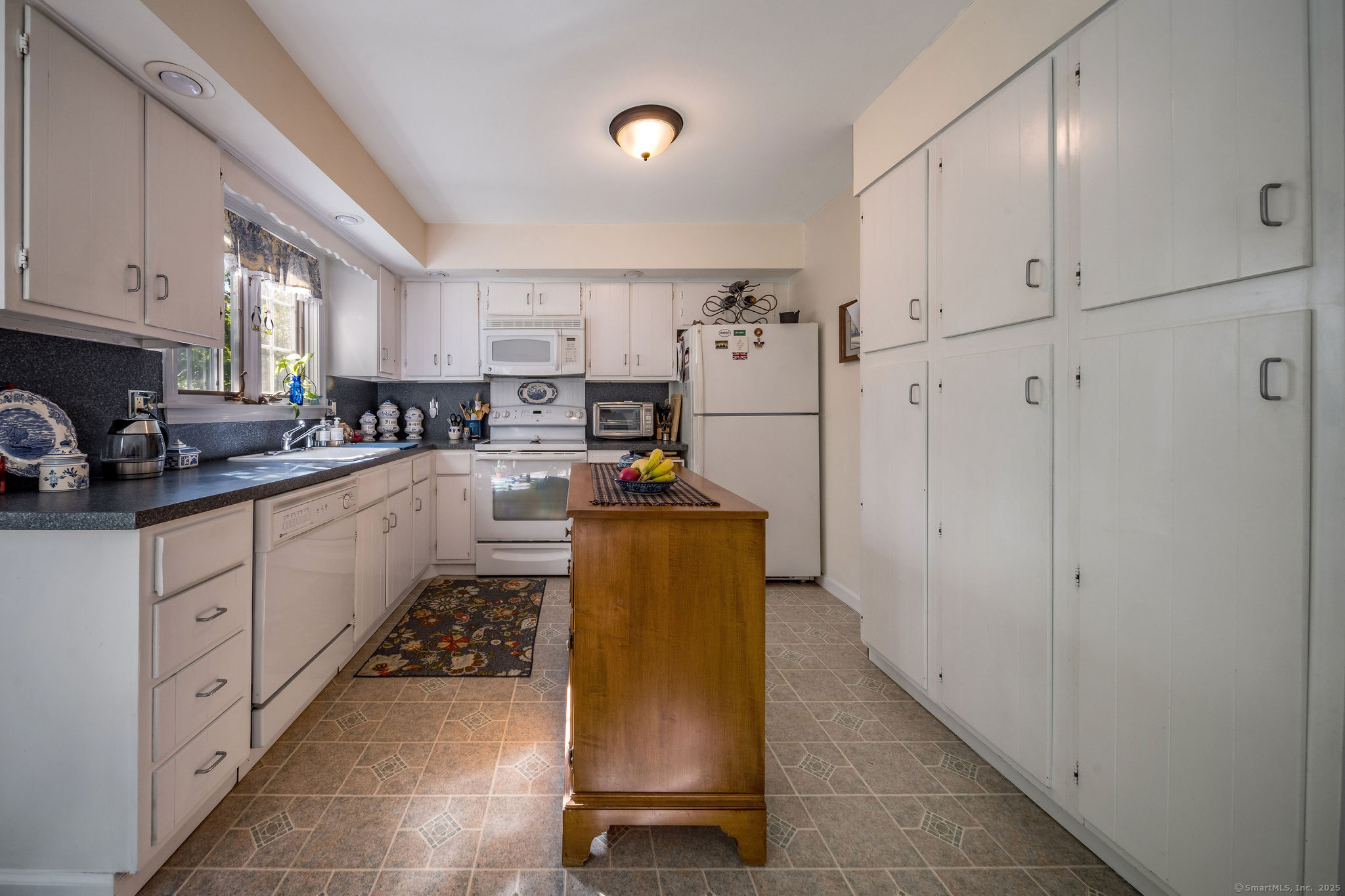 45 Wilshire Road, Unit 45 Madison, CT 06443 - Photo 6 of 25 a kitchen with stainless steel appliances granite countertop a refrigerator a stove a sink dishwasher and white cabinets with wooden floor
