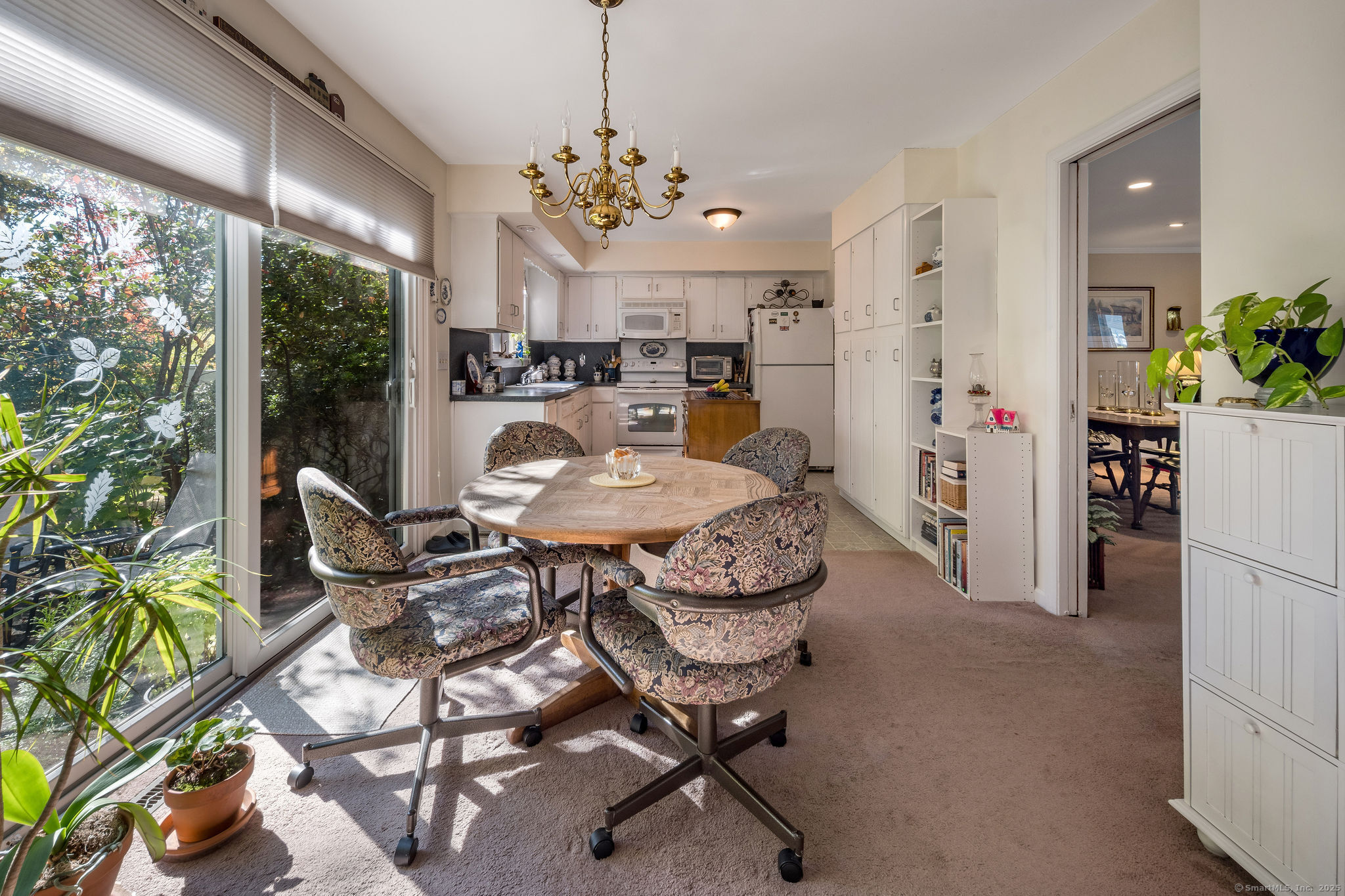45 Wilshire Road, Unit 45 Madison, CT 06443 - Photo 9 of 25 a living room with furniture a chandelier and a dining table