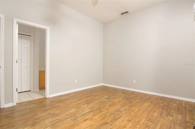 a view of an empty room with wooden floor