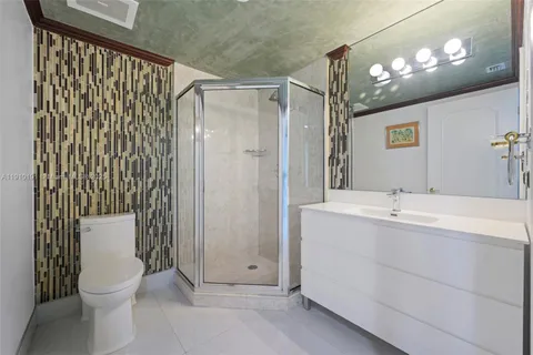a bathroom with a granite countertop sink a toilet and shower