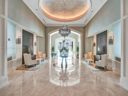 a living room with dining table and a chandelier