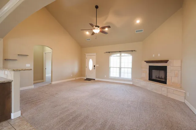 an empty room with windows and fireplace