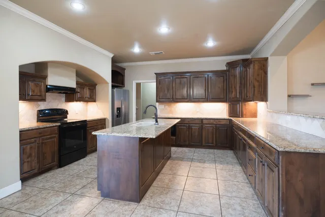 a kitchen with a stove sink and cabinets