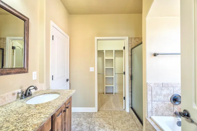 a bathroom with a granite countertop sink and a mirror