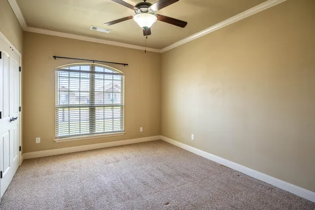 an empty room with windows and fan